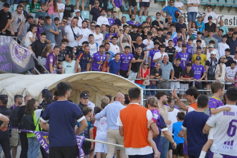 Aficionados del Palencia CF en un partido de fútbol con tensión y emociones.