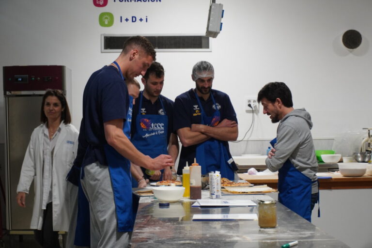 Jugadores del Súper Agropal Palencia Baloncesto preparando pizzas en CETECE.