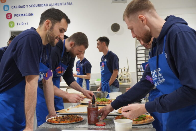 Jugadores del Súper Agropal Palencia Baloncesto preparando pizzas en CETECE