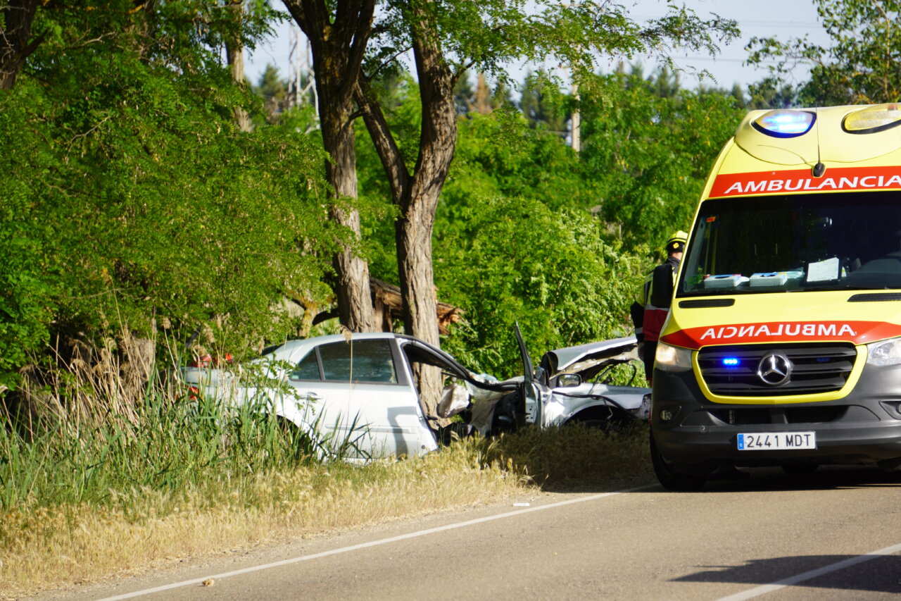 Ambulancia y vehículo accidentado en la carretera de Palencia a Villamuriel