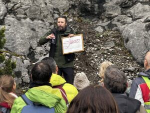 Guía explicando formaciones geológicas a un grupo en Aguilar de Campoo