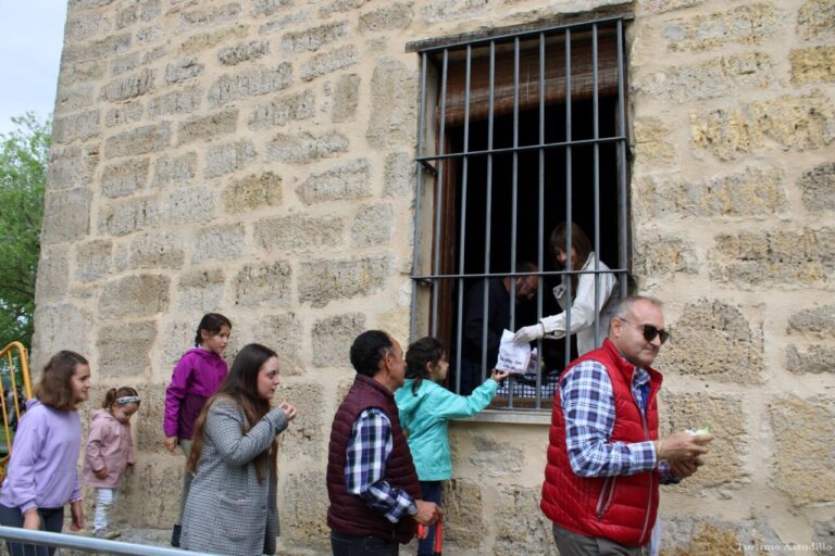 Personas recibiendo alimentos en la romería del Voto Villa en Astudillo