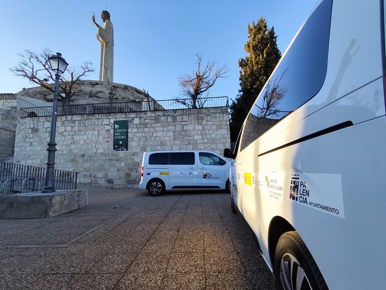 Vista del Cristo del Otero con vehículos de transporte en primer plano.
