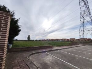 Vista del terreno donde se proyecta un bosque en Grijota con urbanizaciones al fondo
