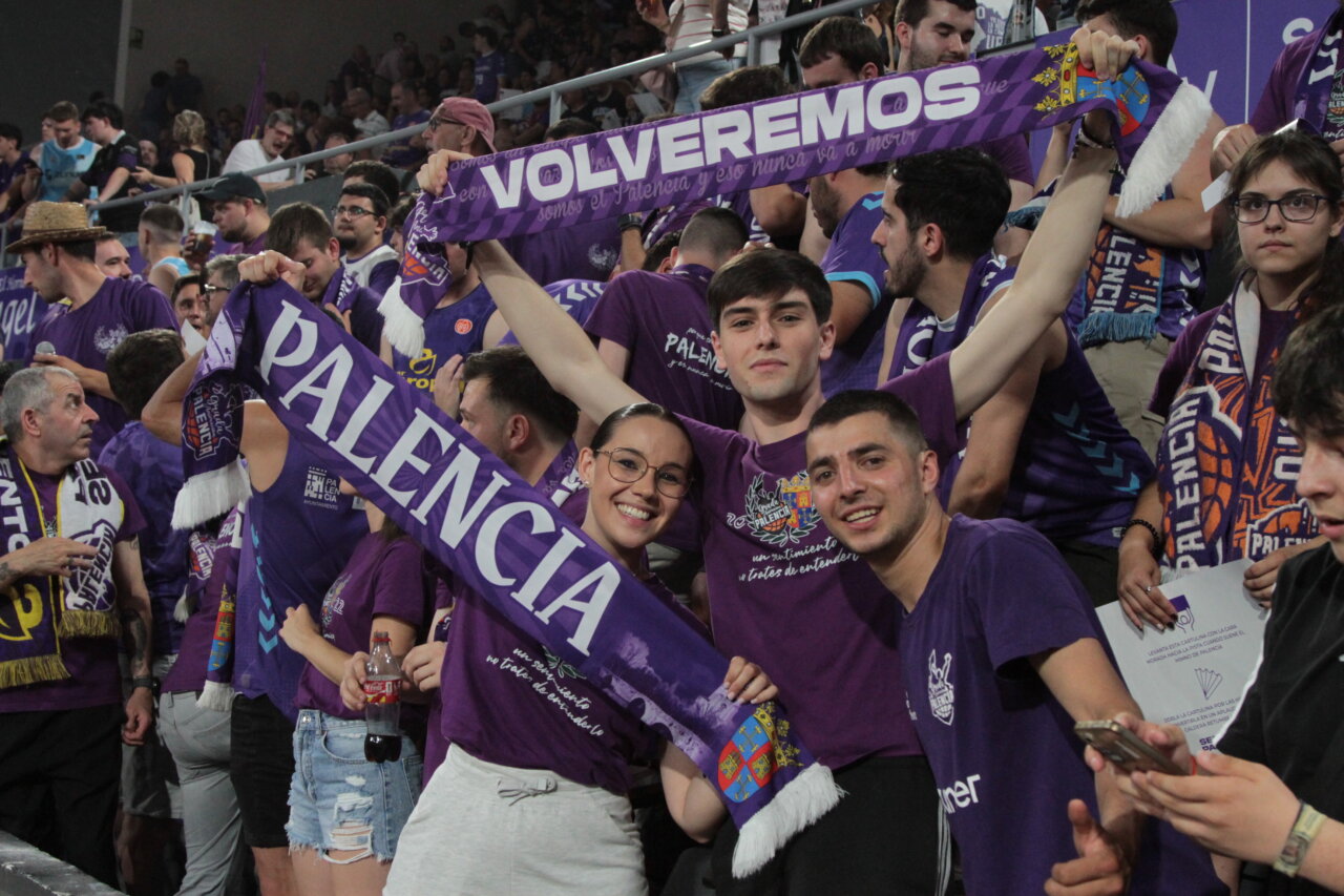 Grupo de jóvenes animando en un evento deportivo con bufandas de Palencia