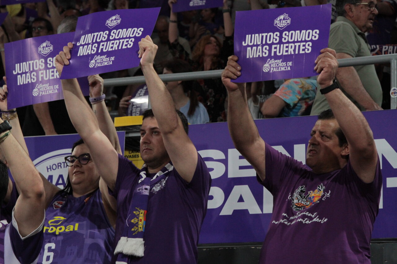 Aficionados sosteniendo carteles en un evento deportivo en Palencia