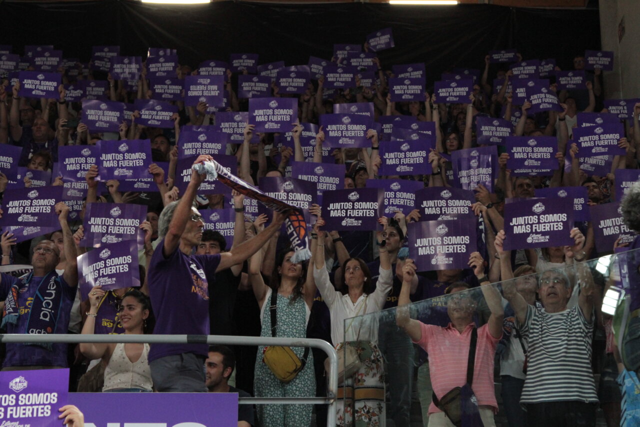 Aficionados sosteniendo carteles en un evento deportivo