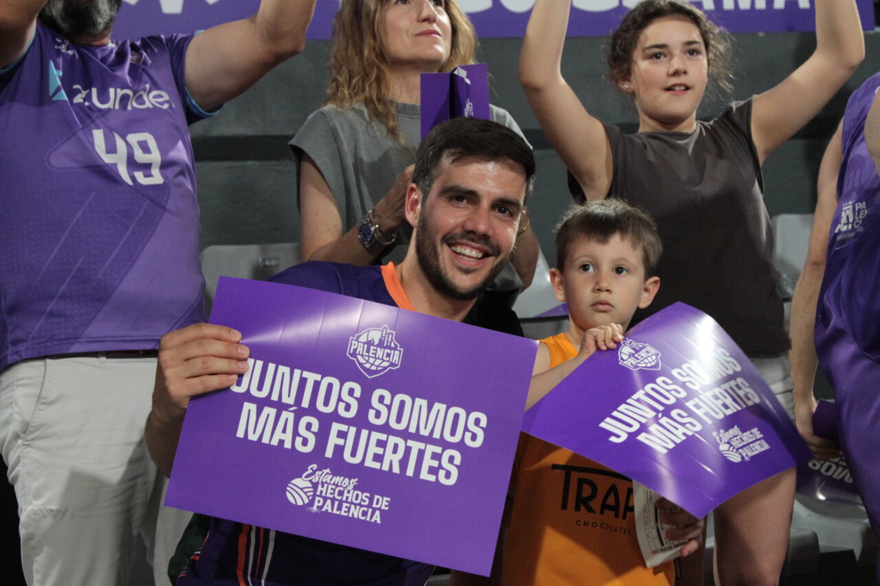 Familia y aficionados sosteniendo carteles en evento deportivo en Palencia