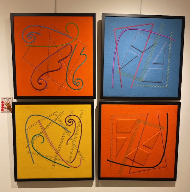 Cuatro cuadros con texturas y hilos de colores en exposición