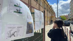Niña observando posters en una exposición escolar sobre móviles