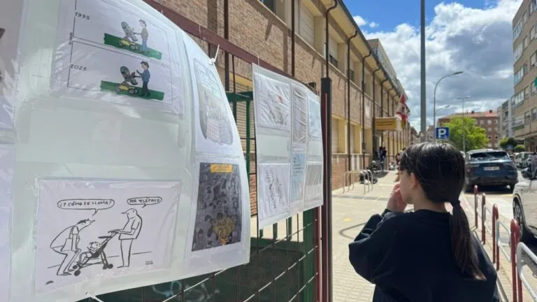 Niña observando posters en una exposición escolar sobre móviles