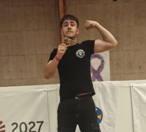 Joven boxeador del Spartans Boxing Club mostrando su medalla en el podio