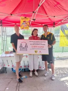 Tres personas sosteniendo un cartel del torneo solidario Cruz Roja