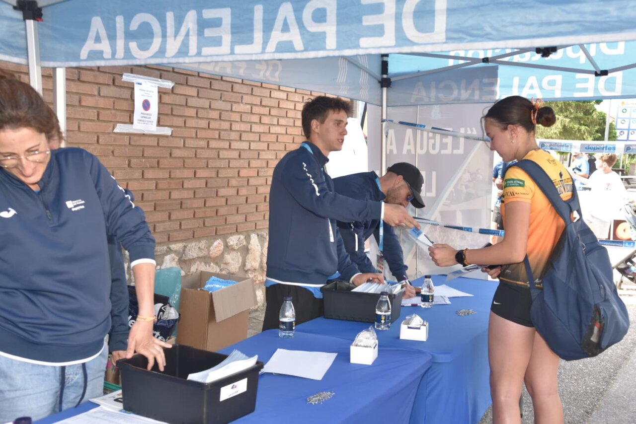 Participantes en la Legua de Quintana recibiendo información en un stand