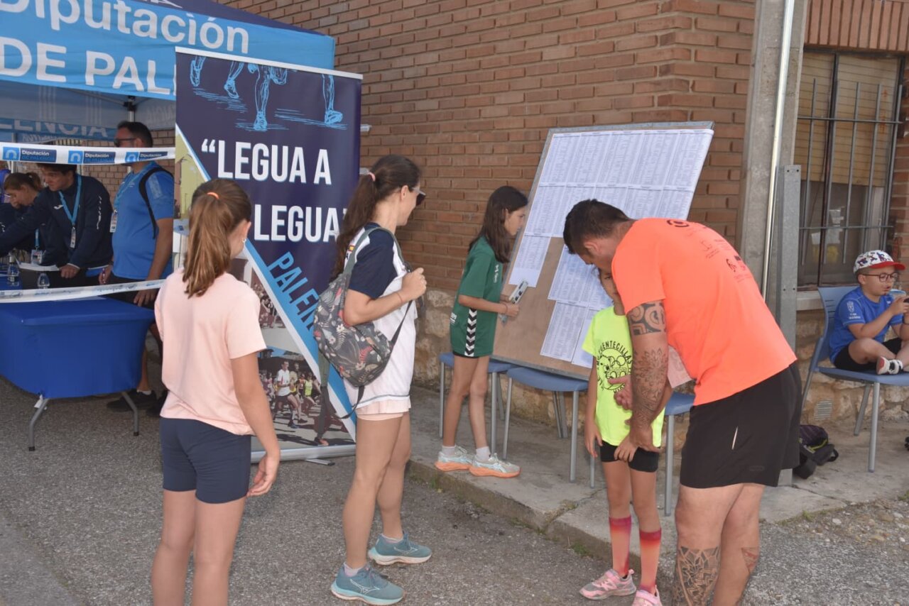 Participantes en la Legua de Quintana revisando resultados en un evento deportivo.