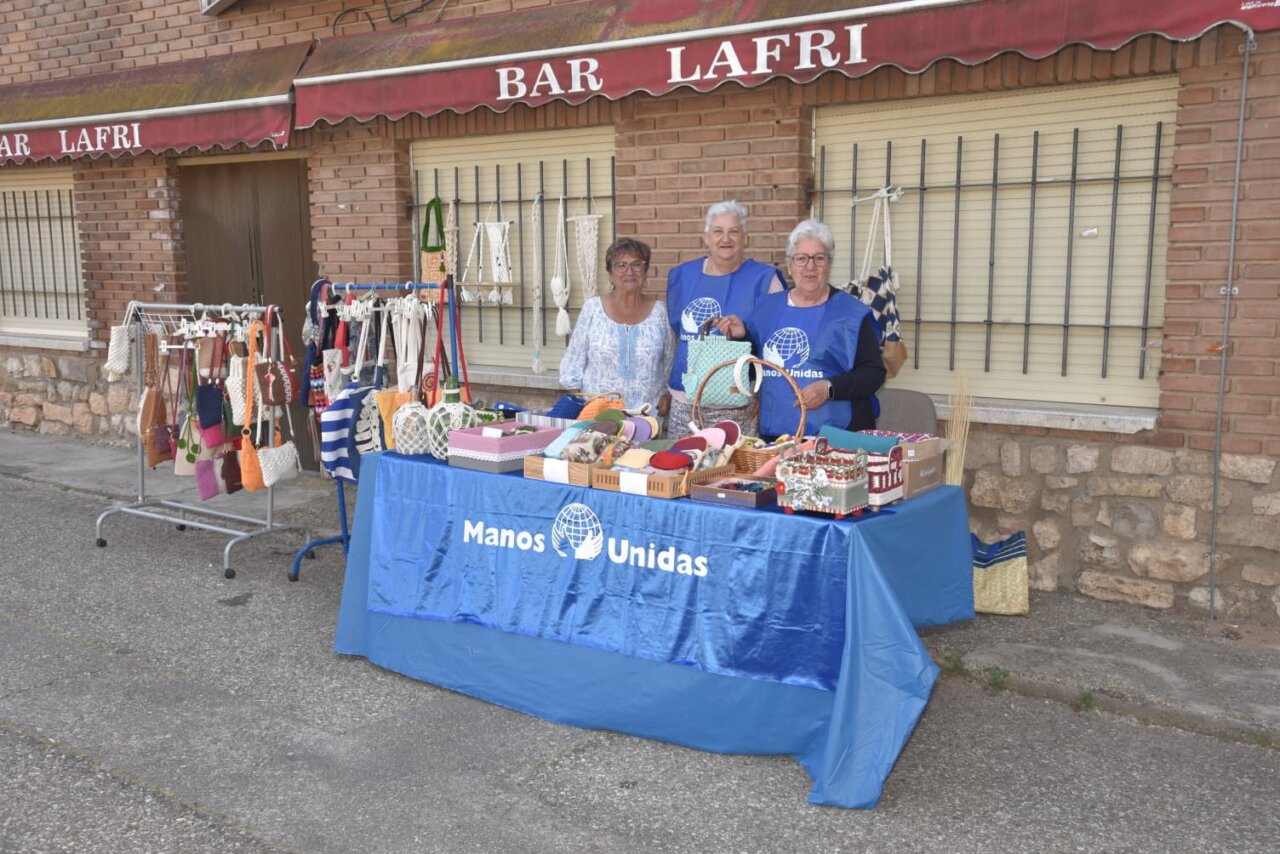 Tres mujeres en un puesto de venta de artesanías en Quintana del Puente