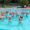 Grupo de personas realizando actividad física en una piscina con flotadores