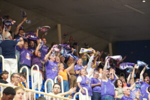 Aficionados animando en un partido de baloncesto con bufandas
