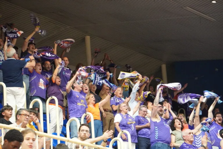 Aficionados animando en un partido de baloncesto con bufandas