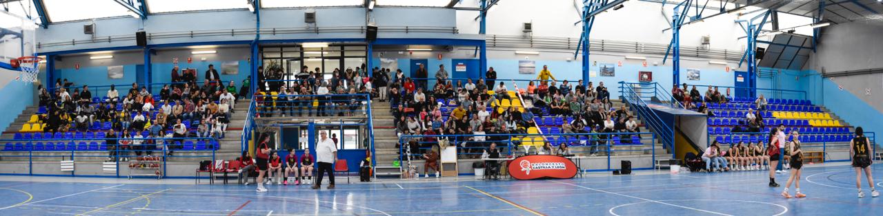 Vista del partido de baloncesto femenino en Venta de Baños con público animando.