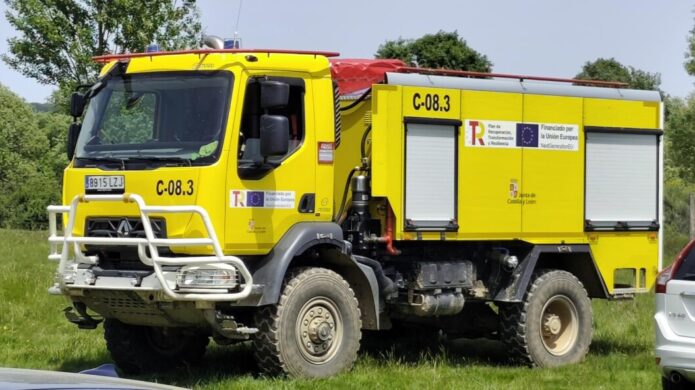 Camión de bomberos amarillo estacionado en un campo verde