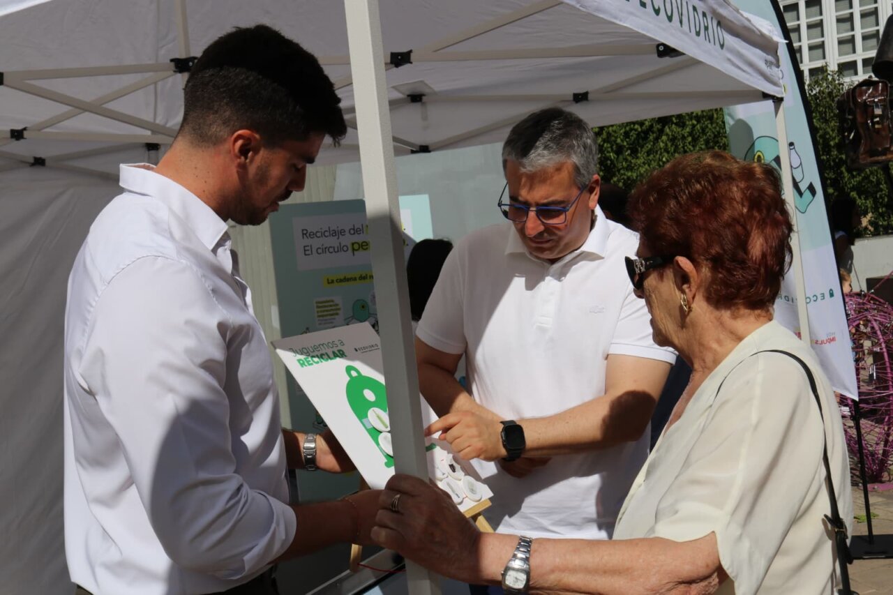 Personas interactuando en un evento de reciclaje de vidrio en Palencia