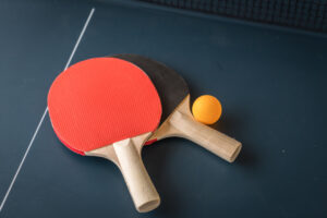 Raquetas de tenis de mesa y una pelota sobre una mesa