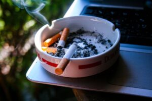 Cenicero con varios cigarrillos y humo saliendo