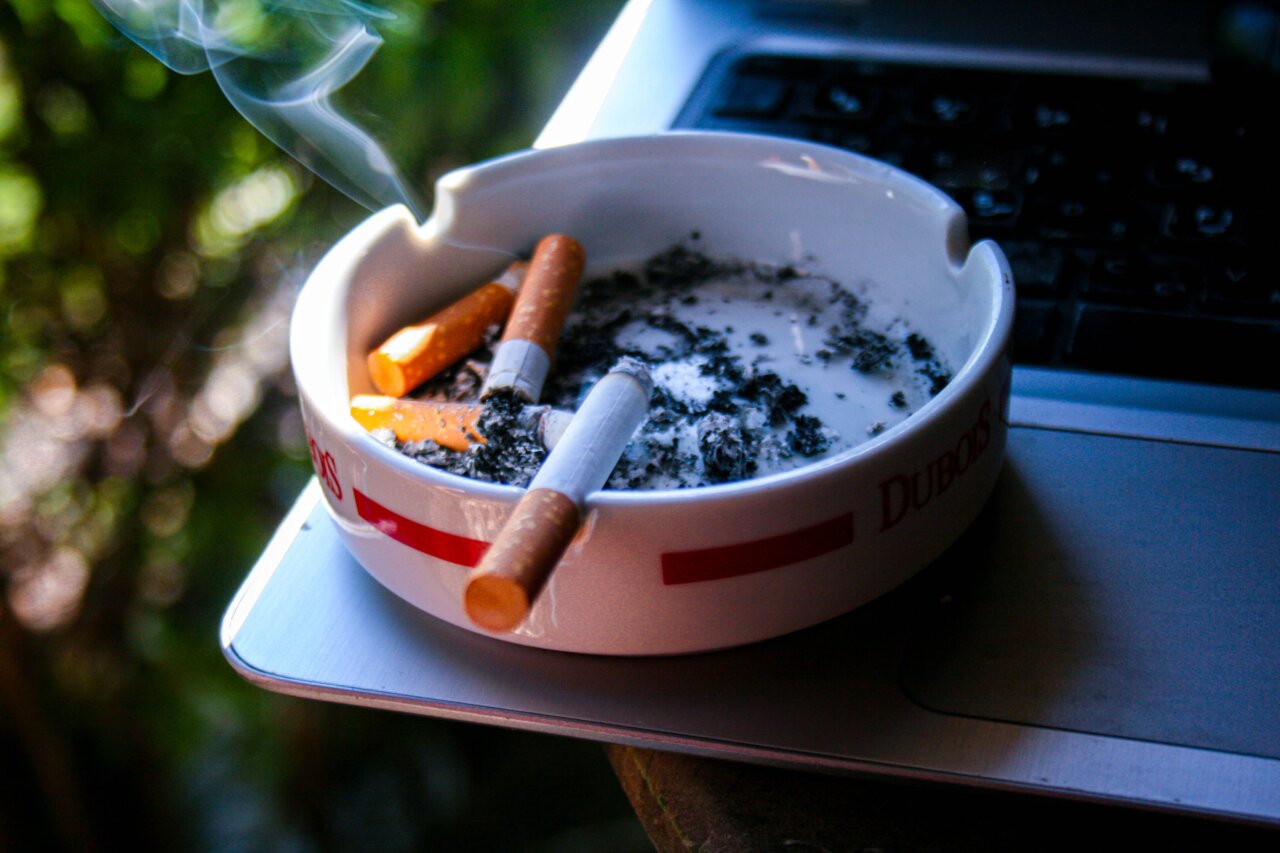 Cenicero con varios cigarrillos y humo saliendo