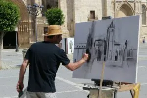 Artista pintando en la plaza durante el certamen de pintura en Palencia