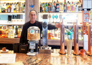 Carlos en la barra de Cervecería La Peseta con bebidas y decoración