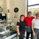 Tres personas sonriendo en un negocio de comida para llevar.