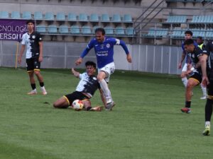 Jugadores de fútbol en un partido disputando el balón en el campo