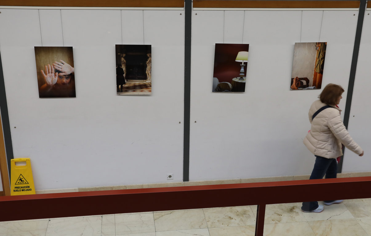 Persona caminando frente a una exposición en la biblioteca pública de Palencia