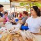 Personas en la Feria del Pan de Grijota con productos de panadería