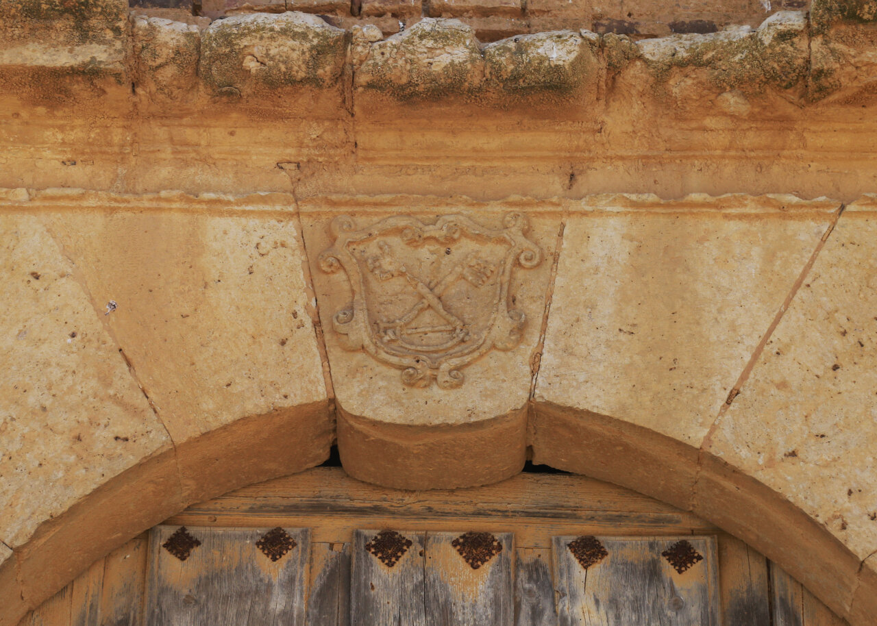 Escudo tallado en piedra sobre la entrada de la iglesia de San Pedro
