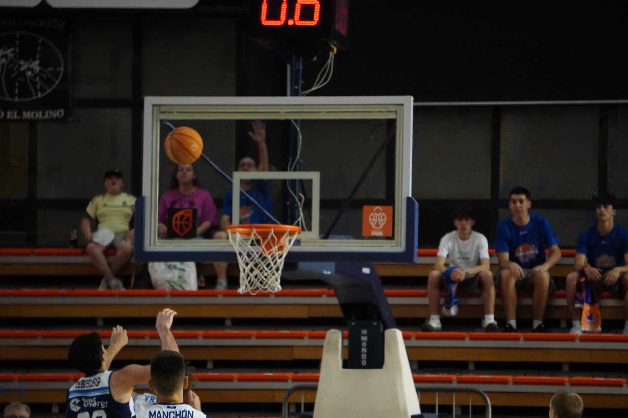 Jugador de baloncesto lanzando un balón hacia la canasta en un partido