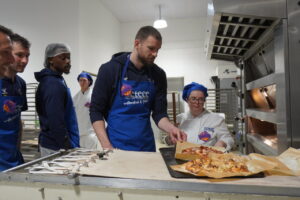Jugadores del Súper Agropal Palencia Baloncesto preparando pizzas en CETECE