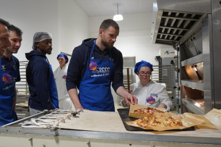 Jugadores del Súper Agropal Palencia Baloncesto preparando pizzas en CETECE