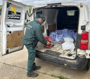 Agente de la Guardia Civil inspeccionando un vehículo con trofeos de caza