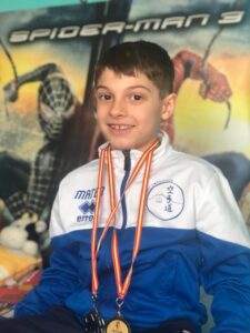 Mateo Zapatero, joven karateka con medallas, sonriente en su entrenamiento.