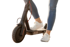 Mujer joven montando un scooter eléctrico en la ciudad