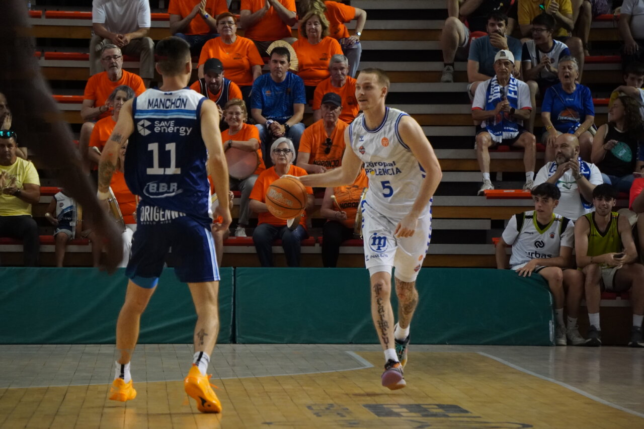 Jugadores de baloncesto en un partido en Palencia con aficionados animando.