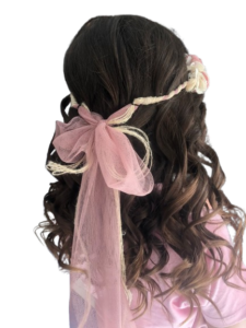 Peinado para niña con trenza y lazo rosa en la parte posterior.