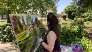 Artista pintando al aire libre en Saldaña, rodeada de naturaleza