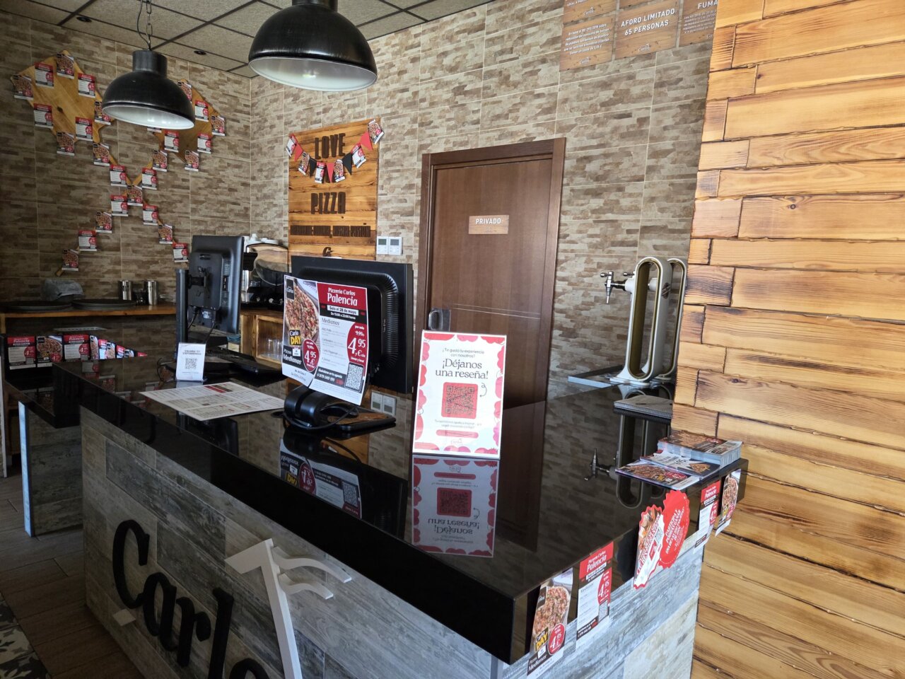 Interior de la Pizzería Carlos con decoración y menú visible