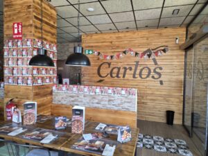 Interior de la Pizzería Carlos con decoración de madera y menús en las mesas