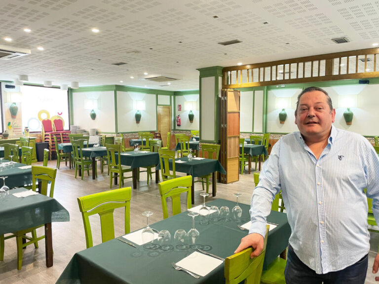 Interior del restaurante La Cántara con mesas y sillas verdes