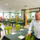 Interior del restaurante La Cántara con mesas y sillas verdes