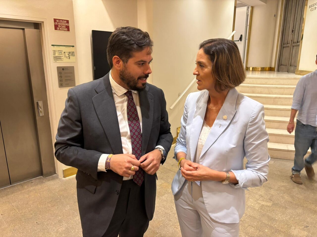 Subdelegado del Gobierno y exministra de Industria conversando en un evento.